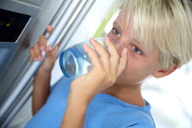 Family safe drinking water. Boy drinking water.
